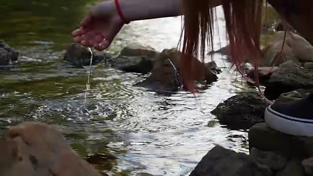 女孩用手触摸河中的水视频素材