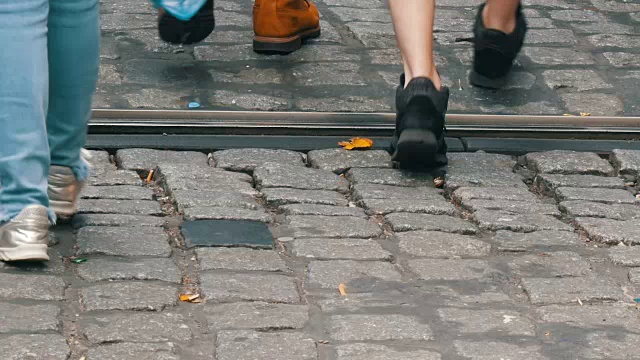 一大群人在城市的鹅卵石路上漫步视频素材