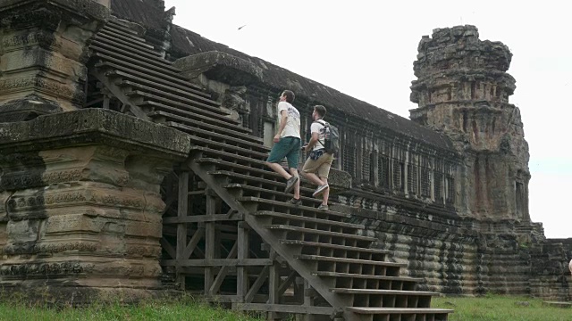 两位白人游客攀登吴哥窟寺庙视频素材