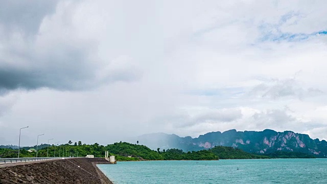 时间推移拍摄的大坝与热带森林和山与雨和风暴云的背景视频素材