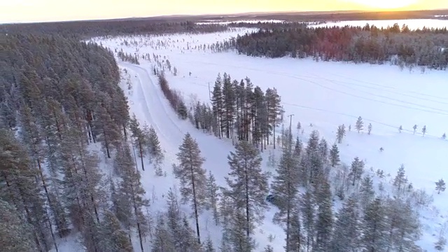 芬兰，汽车在滑滑的雪道上行驶，穿越森林荒野视频素材