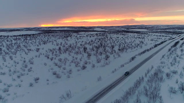 摄影:日出时，汽车在雪地上行驶，穿越风景优美的冬季乡村视频素材