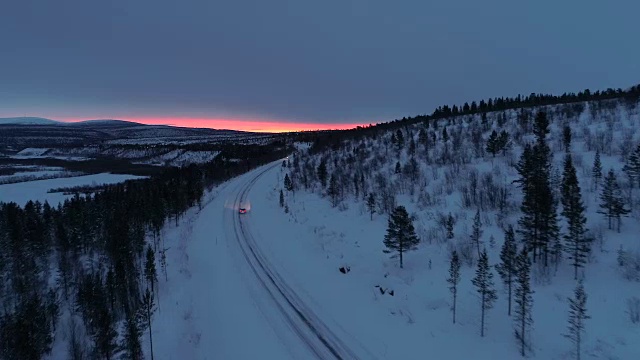 摄影:日出时分，汽车行驶在雪山公路上穿过松林视频素材