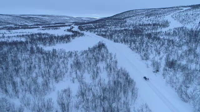 空中汽车在雪道上行驶，穿过令人惊叹的山区冬季景观视频素材