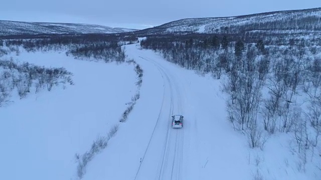 空中汽车在雪道上行驶，穿过令人惊叹的山区冬季景观视频素材