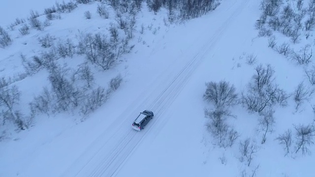 空中汽车在雪地上行驶，经过光秃秃结霜的树木视频素材