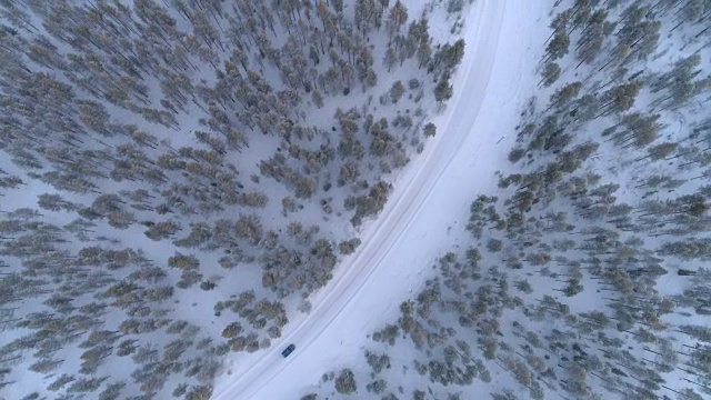 空中俯瞰:汽车在冬日仙境的雪道上行驶视频素材