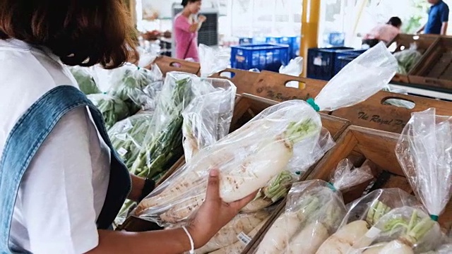 年轻女子在商店挑选蔬菜视频素材