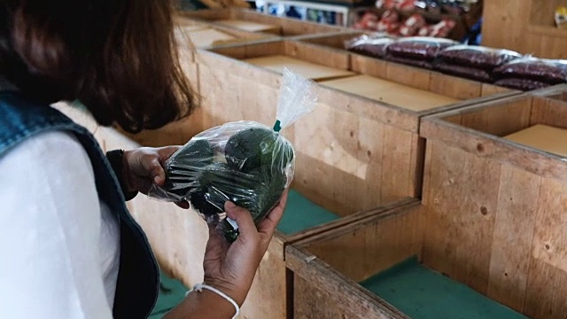 年轻女子在商店挑选蔬菜视频素材