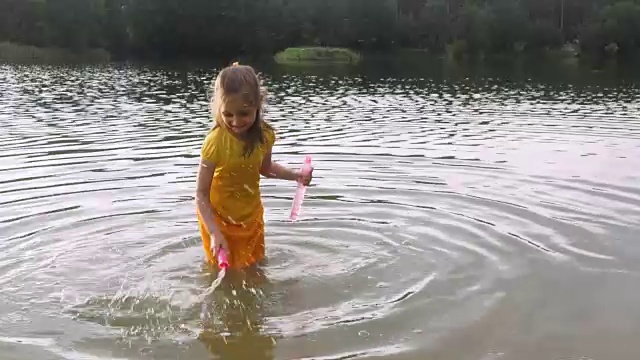 小女孩拿着泡泡棒在水潭里。视频素材