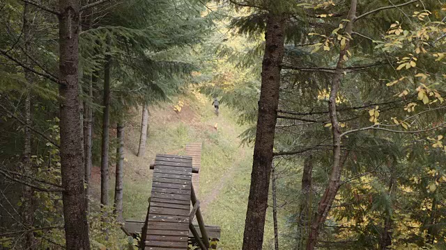 4K SLO MO:山地摩托车手在森林里的斜坡上下车视频素材