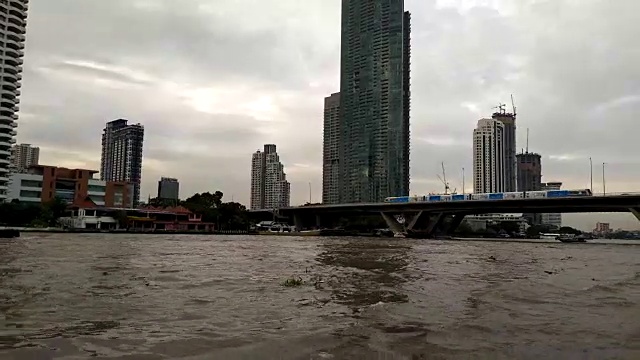 夕阳西下，在曼谷湄南河上的一艘小船上航行。湄南河上有许多豪华酒店和公寓。视频素材