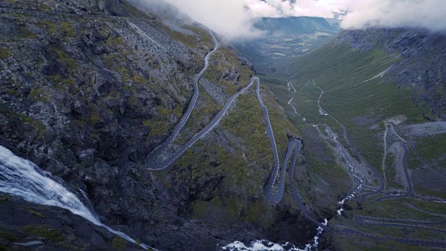 4K Trollstigen路挪威汽车和瀑布从鸟瞰图，倾斜下左视频素材