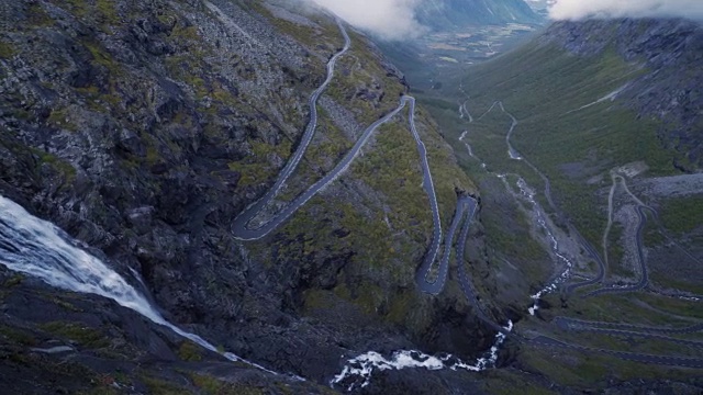 4K Trollstigen路挪威汽车和瀑布鸟瞰图，潘右视频下载