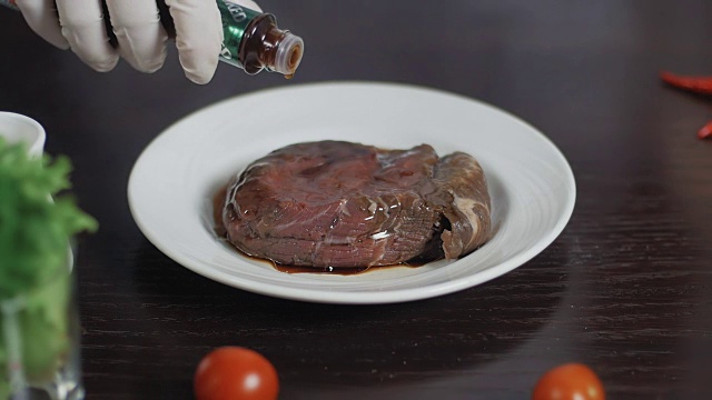 近距离腌制肉类。把酱油和肉一起倒进盘子里视频素材