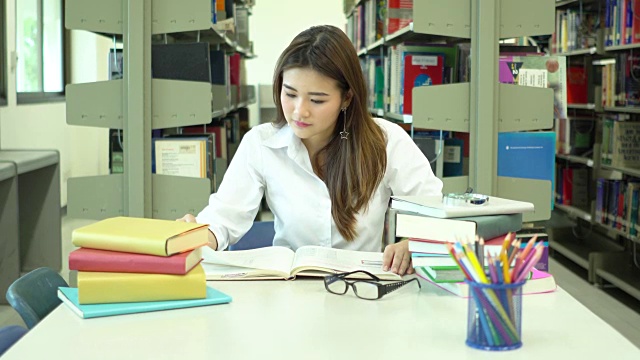 亚洲女学生在学校图书馆看书视频素材