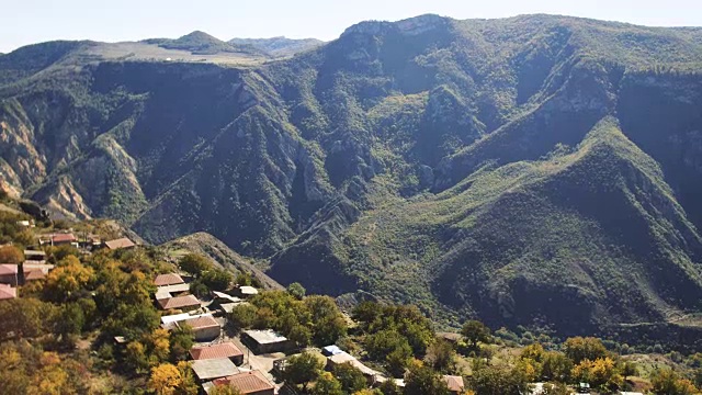 鸟瞰图:鸟瞰森林里的秋日山村，日出的柔和光线。美丽的景观视频素材