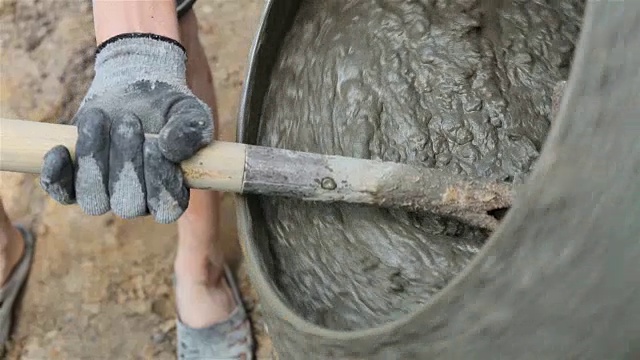 工人在混凝土搅拌机里搅拌混凝土。视频素材