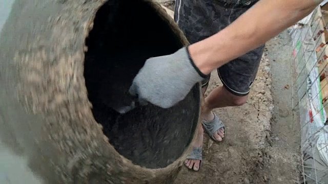 工人在混凝土搅拌机里搅拌混凝土。视频素材