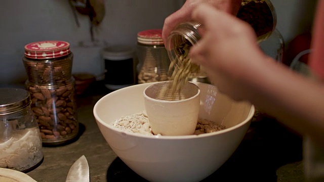 妇女插入麦片/格兰诺拉麦片配料碗视频素材