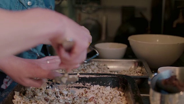 妇女准备食物，混合麦片/格兰诺拉麦片，磨碎橙子视频素材