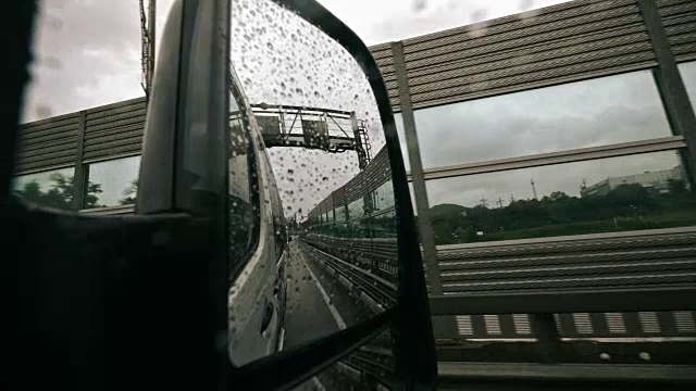 车辆在雨中从后视镜，驾驶汽车，暴风雨在道路上，高速公路，雨点在缓慢的运动视频素材