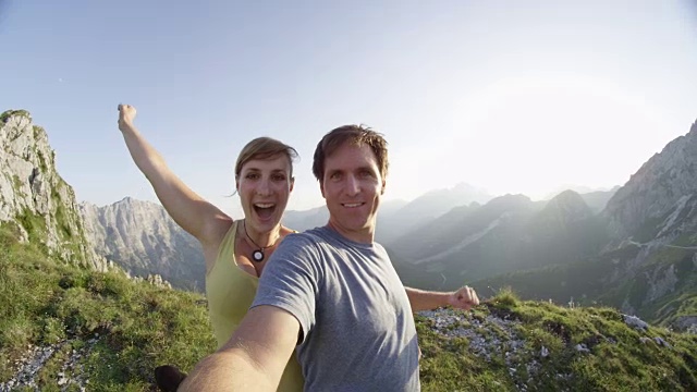 肖像:欢快的年轻徒步旅行夫妇庆祝征服高山顶视频素材