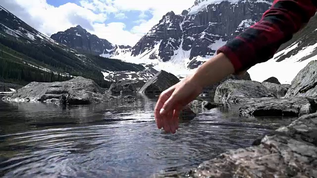 手杯从遥远的山湖抓水视频素材