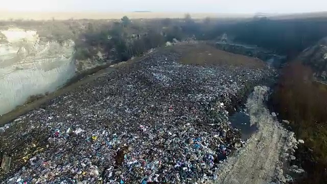 航拍:推土机在一个巨大的垃圾场里铲垃圾视频素材