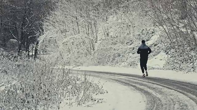 森林雪道上的慢跑者视频素材