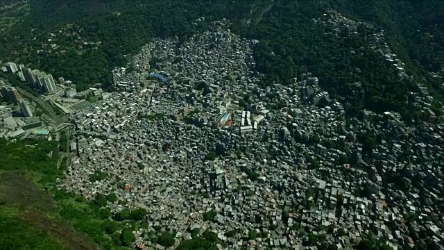 贫民窟空中:从森林上方缓慢地向侧面展示巴西里约热内卢的Rocinha Favela视频素材