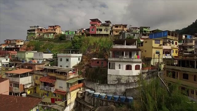 贫民窟航拍:飞跃贫民窟山顶，展示背后的海岸小镇安格拉。多斯。雷斯视频素材