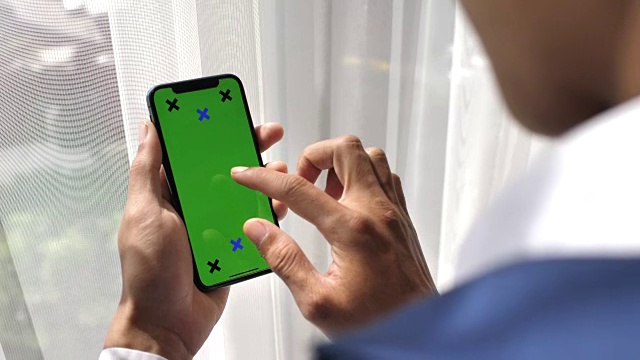 商人看智能手机与绿色屏幕手持智能手机，iPhone X视频素材