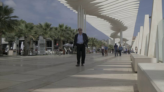 人们走过Paseo Del Muelle Uno，马拉加，安达卢西亚，西班牙，欧洲视频素材