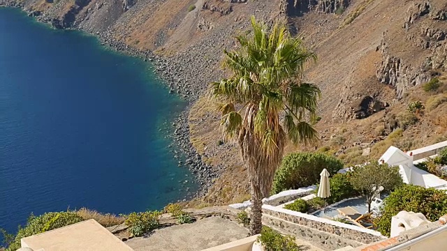 深蓝色的海水冲刷着希腊圣托里尼火山岛的岩石海滩视频素材