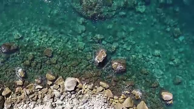 海浪撞击海岸线岩石的鸟瞰图视频素材