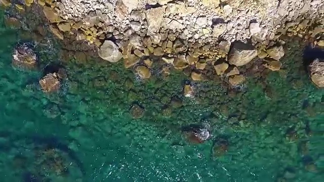 海浪撞击海岸线岩石的鸟瞰图视频素材