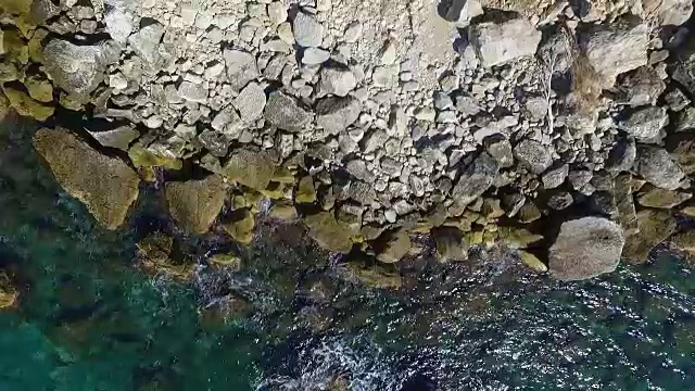 海浪撞击海岸线岩石的鸟瞰图视频素材