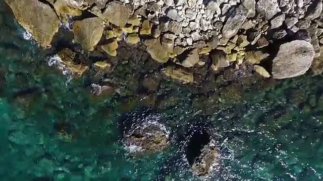 海浪撞击海岸线岩石的鸟瞰图视频素材