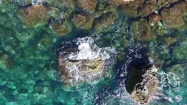 海浪撞击海岸线岩石的鸟瞰图视频素材