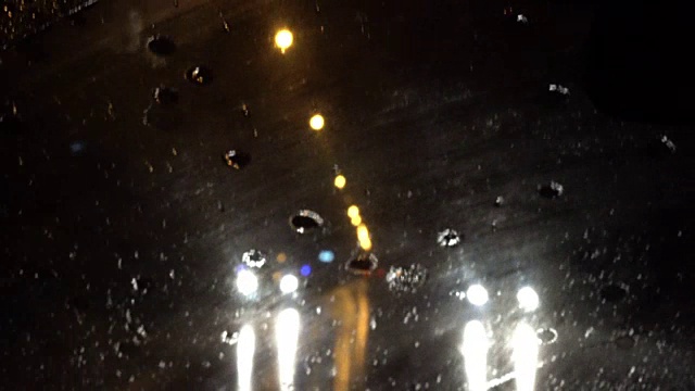 4k夜间雨点落在挡风玻璃上视频素材