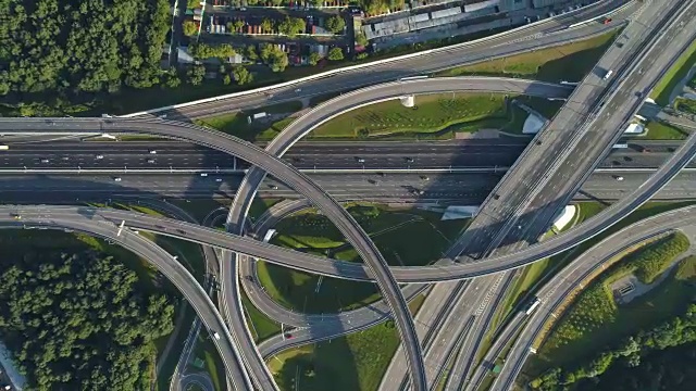 多层次的道路交汇处和汽车交通。无人机旋转着飞起来。空中垂直拍摄。视频素材