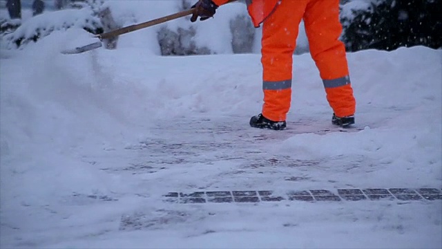 工人们在冬天清扫路上的积雪。从暴风雪中清理城市视频素材