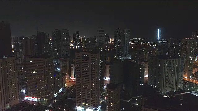 房屋屋顶和灯火通明的街道的夜景。阿联酋沙迦。视频素材