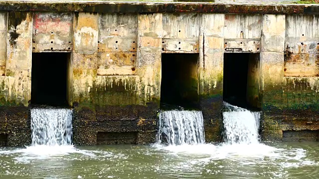 雨后日常生活视频。水从城里的一条运河流向大海。以水浸概念来排水及防止城市水浸。视频素材