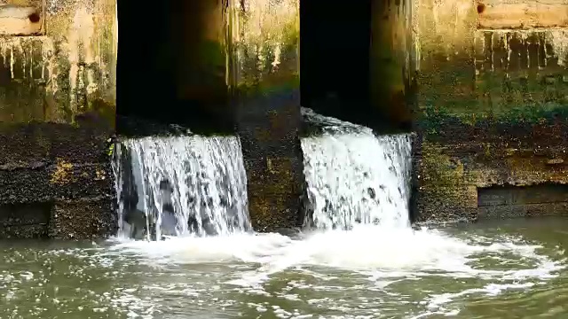 雨后日常生活视频。水从城里的一条运河流向大海。以水浸概念来排水及防止城市水浸。视频素材