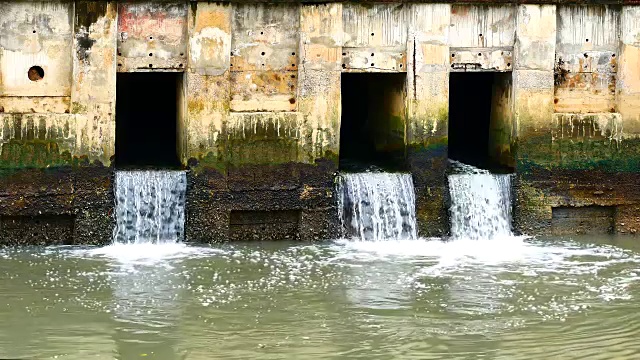 雨后日常生活视频。水从城里的一条运河流向大海。以水浸概念来排水及防止城市水浸。视频素材