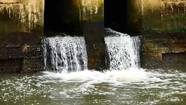 雨后日常生活视频。水从城里的一条运河流向大海。以水浸概念来排水及防止城市水浸。视频素材