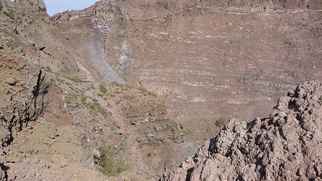 陡峭的岩石峡谷斜坡与干燥稀少的植被在阳光下，序列视频素材