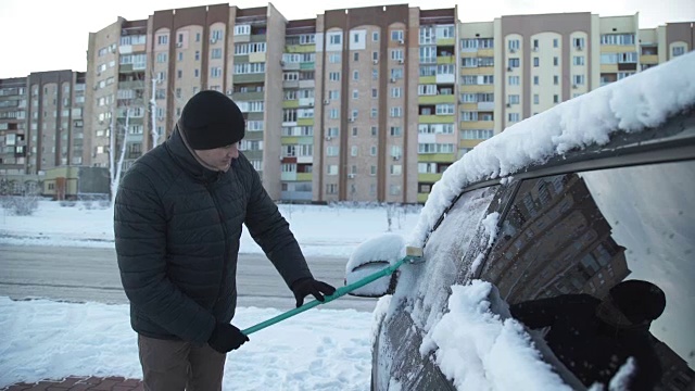 那个人正在清理车上的雪视频素材